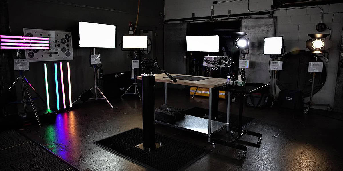 Professional video production setup featuring multiple LED and fluorescent lights, color bars, and a central workstation, illustrating the ideal environment for using versatile cameras like the Sony PMW-300 camcorder for high-quality videography in controlled lighting conditions