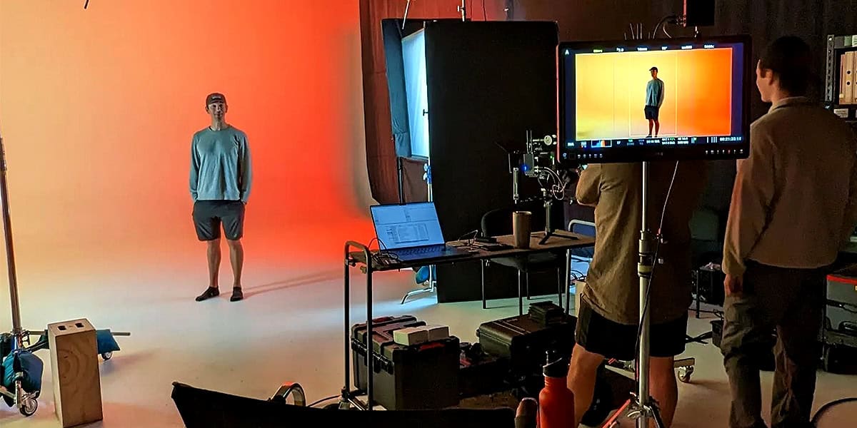 Man being photographed against a coloured background in a Pixthis stage