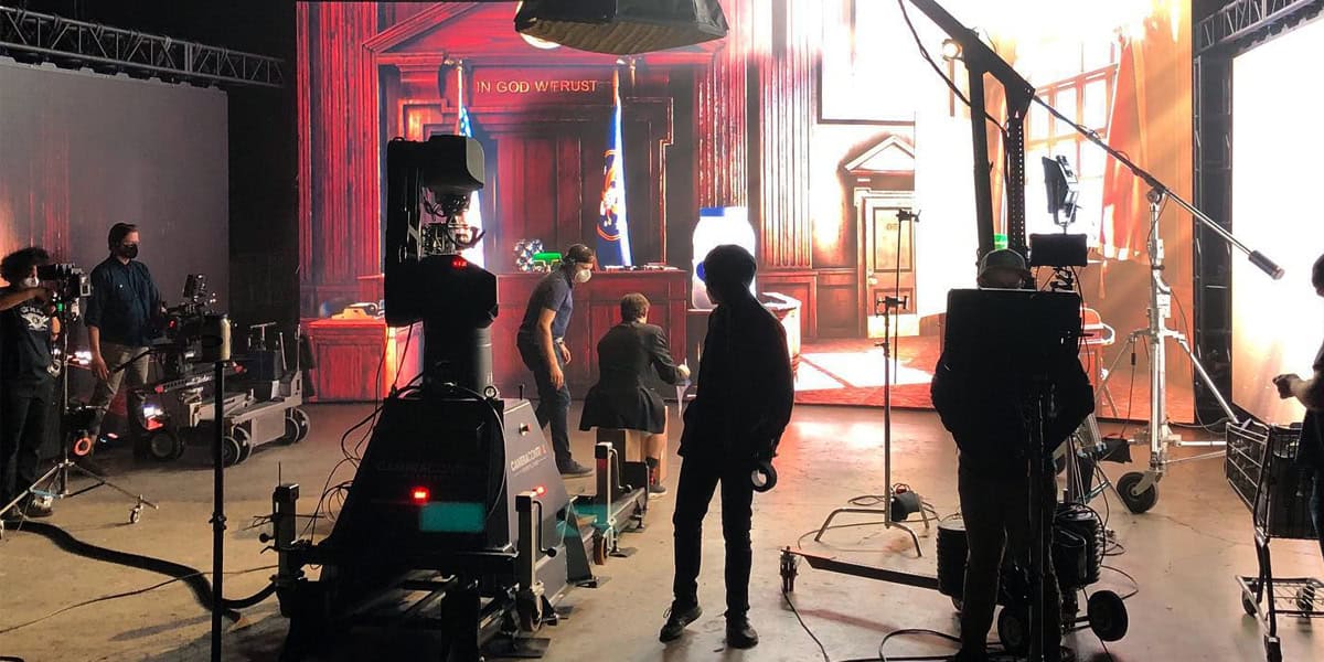 Film crew shooting on an LED volume stage with a courtroom backdrop