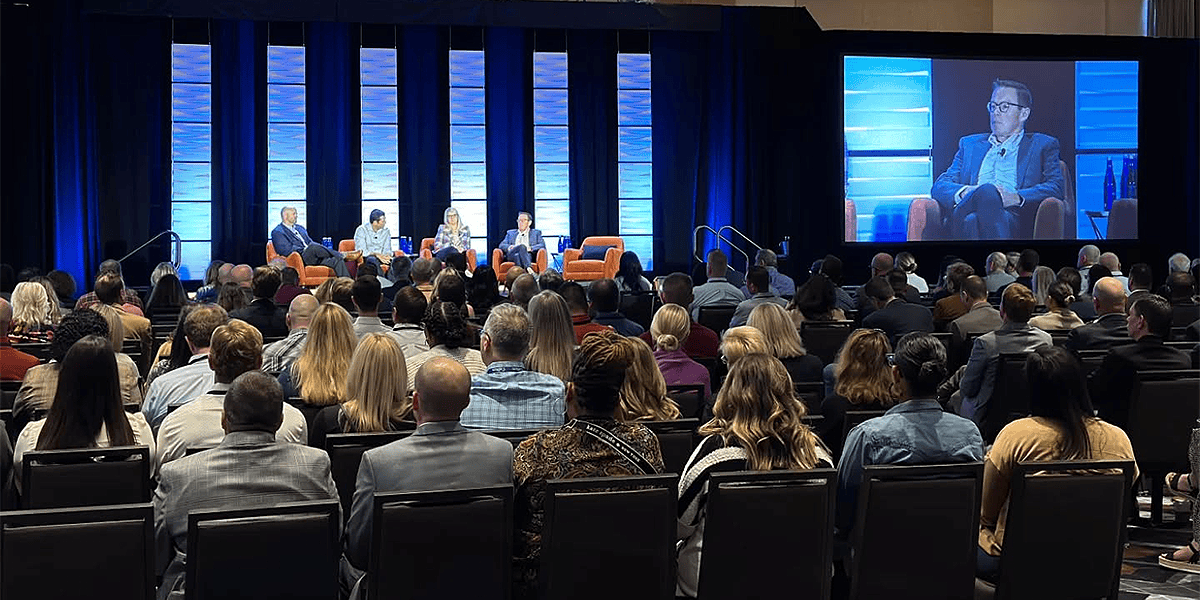 Large Portland conference panel discussion with IMAG screen, professional stage lighting, and full audience by Pixthis AV rentals 